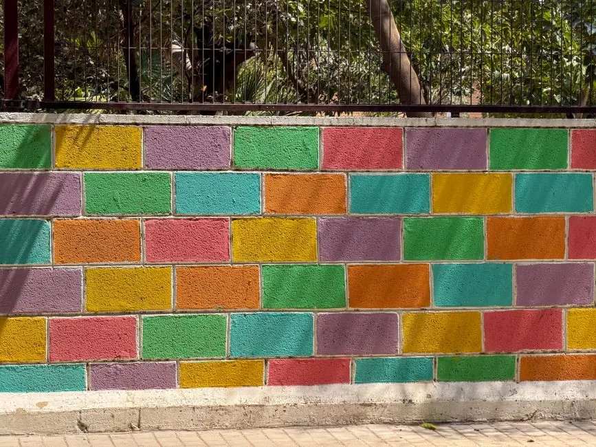 Pared de ladrillos brillantemente coloreada en Valencia, España, mostrando tonos vívidos.