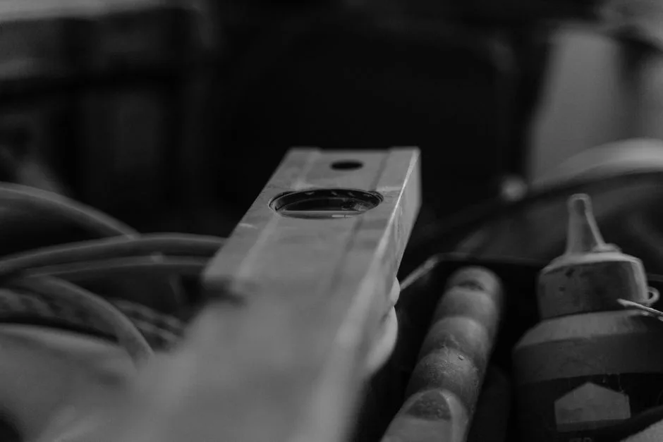 Imagen en blanco y negro de herramientas de construcción en un taller, enfatizando un nivel de burbuja.